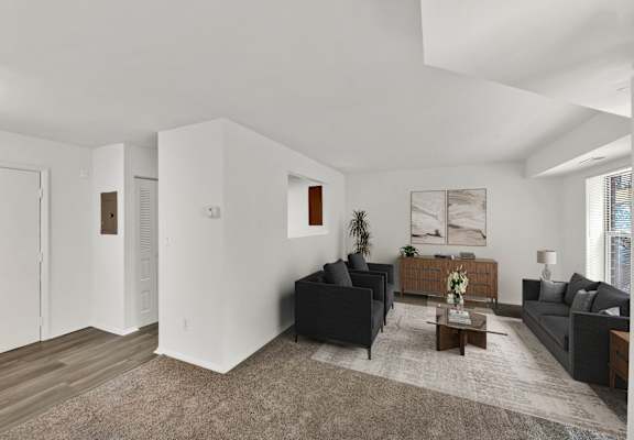 a living room with two black couches and a coffee table
