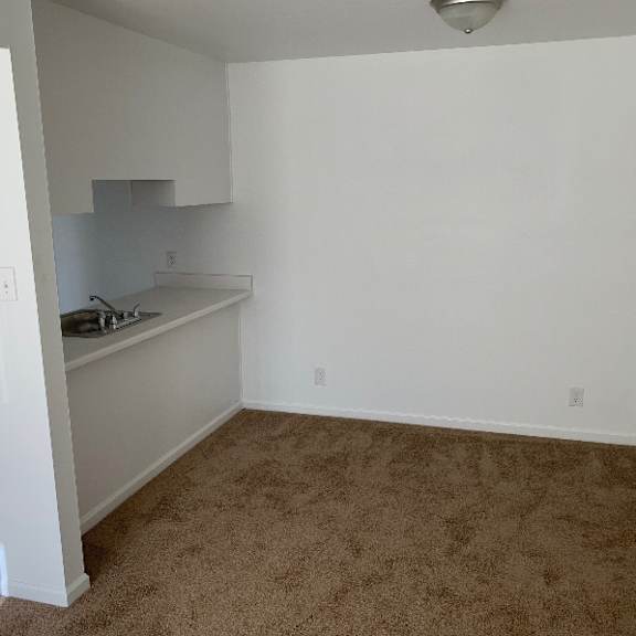 a white bedroom with a large bed and a window