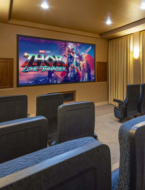 a theater room with chairs and a movie screen