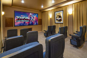 a theater room with chairs and a movie screen