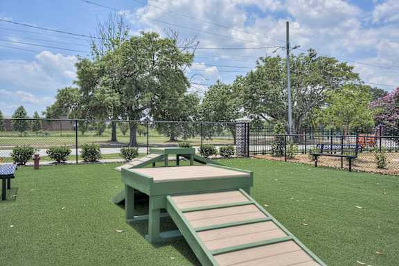 a picnic table and benches in a park with a fence