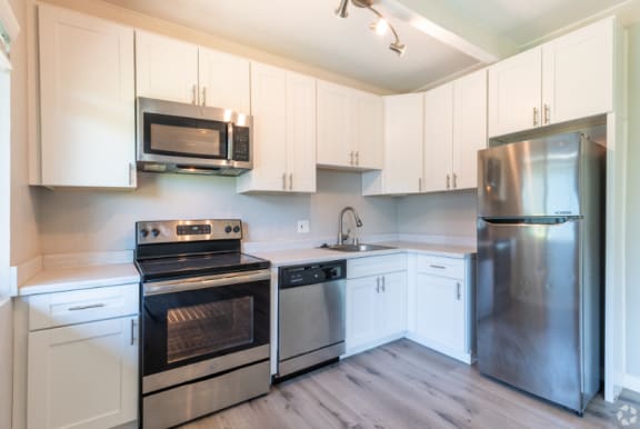 a kitchen with stainless steel appliances and white cabinets