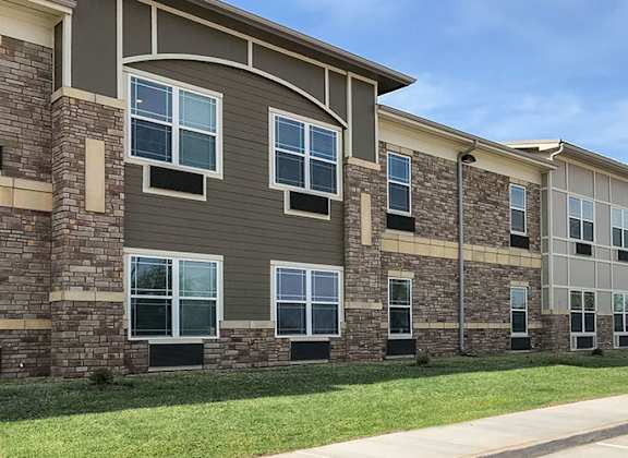 A row of apartment buildings with stone and siding exteriors.