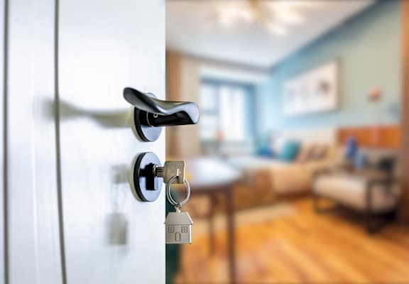 A white door with a black handle and a key in the lock.