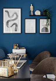 a bedroom with a bed and a nightstand with a lamp and a framed picture