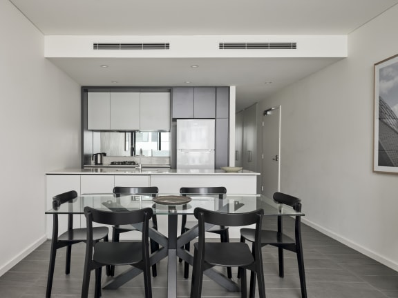 a kitchen and dining area with a glass table and chairs