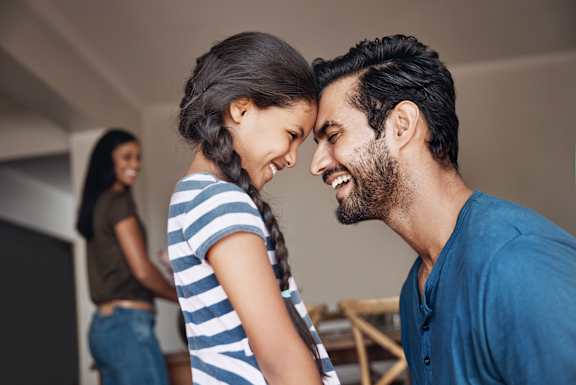 A man and a woman are standing close to each other, the woman is wearing a striped shirt and the man is wearing a blue shirt.
