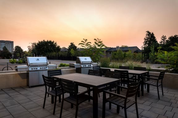 a patio with a table and chairs and a sunset