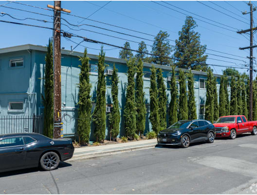 a city street with cars parked in front of a building