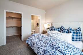 two beds with blue and white comforters in a room with a bathroom