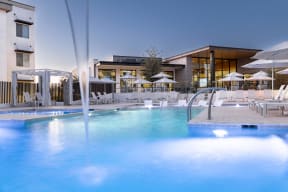 a swimming pool with chairs and umbrellas at a resort