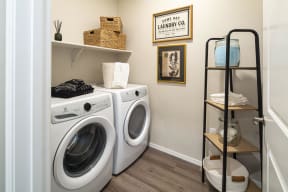 a laundry room with a washing machine and a shelf with towels