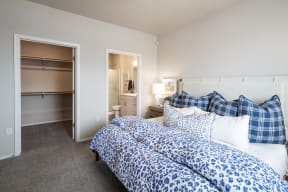 two beds with blue and white comforters in a room with a bathroom