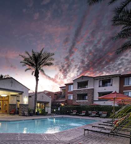 a swimming pool at night at a hotel with palm trees