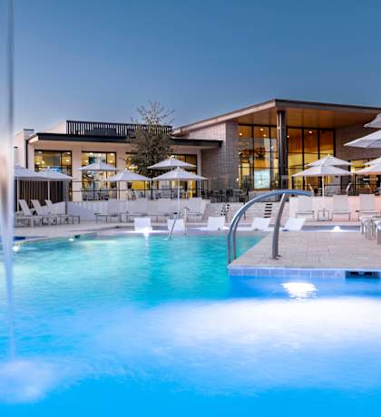 a swimming pool with chairs and umbrellas at a resort