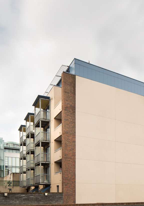 a building with balconies and a cloudy sky in the background