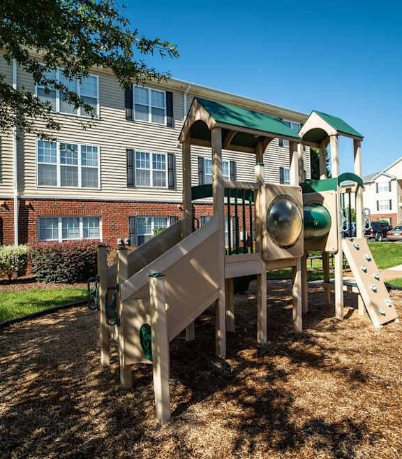 A playground with a slide and a green roof.