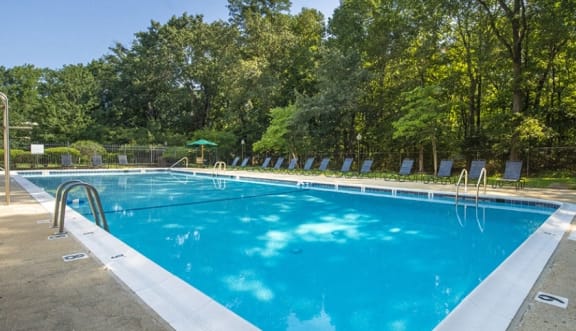 a swimming pool with trees in the background  at Spa Cove Apartments, Annapolis, 21403