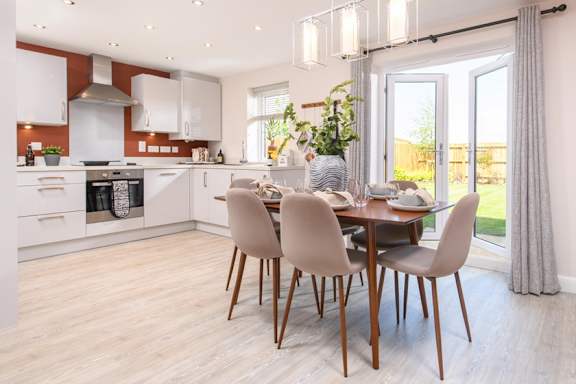 A modern kitchen with a dining table set for four.