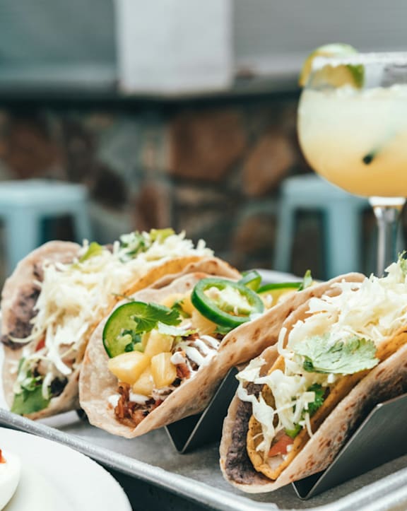Three Tacos with Toppings on Metal Tray