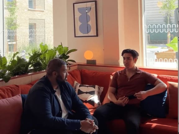 two men sitting on a couch in a living room