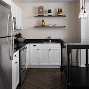a kitchen with white cabinets and a black counter top