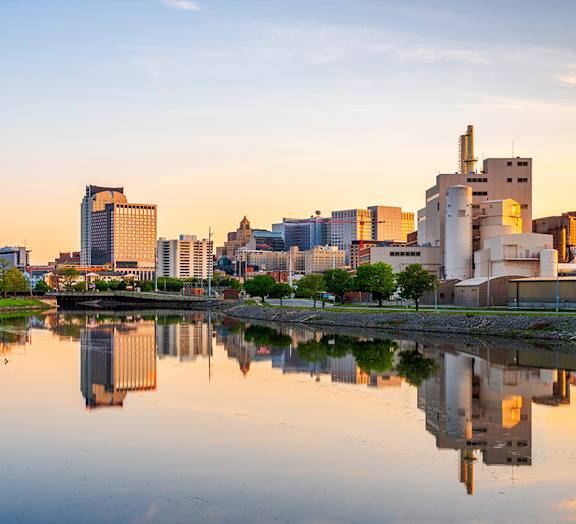 A city skyline is reflected in a body of water.