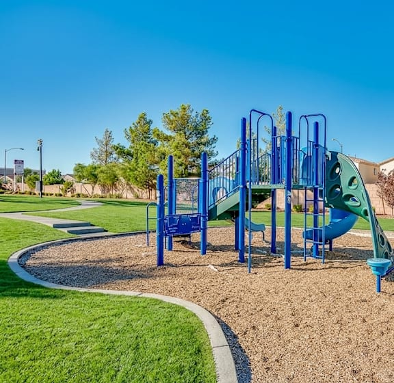 A playground with a blue slide and a green slide.