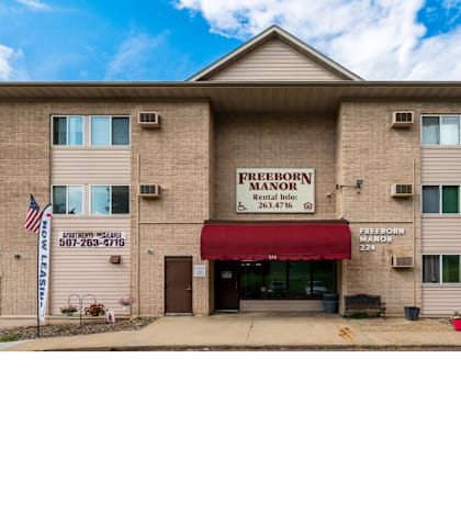 a picture of the front of a building with a red awning
