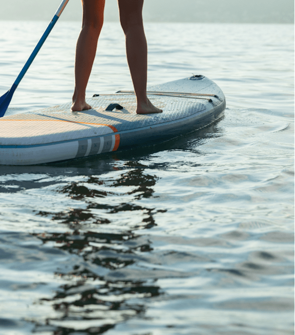 Person Paddleboarding on Calm Body of Water