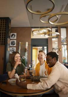 a group of people sitting around a table in a restaurant