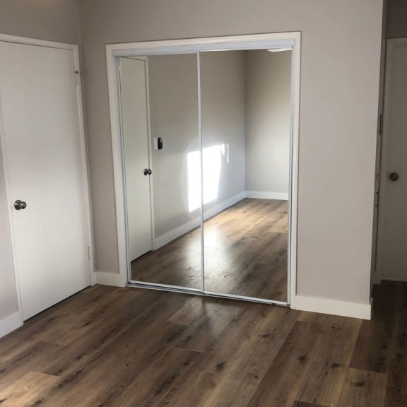 a bedroom with white walls and a large mirror