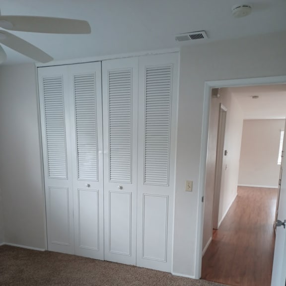 a large white closet in a room with a ceiling fan