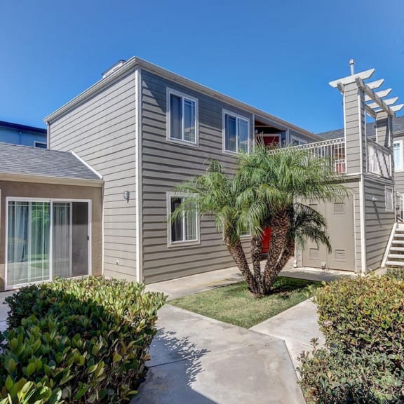 a gray house with a palm tree in front of it