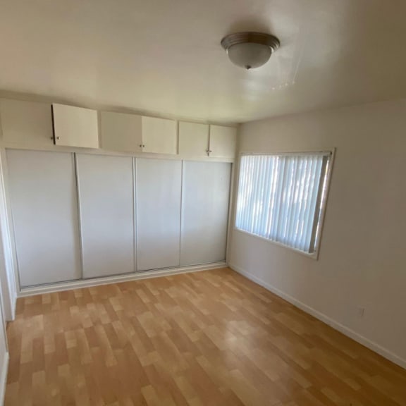 an empty room with a window and white walls