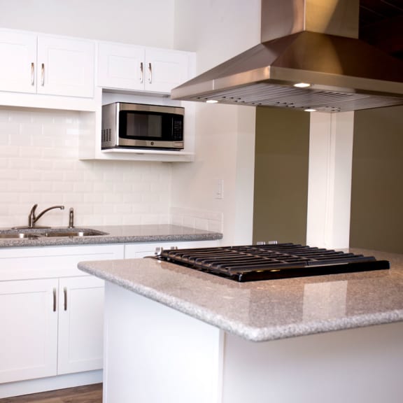 a kitchen with white cabinets and a granite counter top