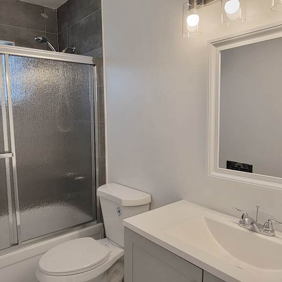 A white toilet sits next to a white sink in a bathroom.