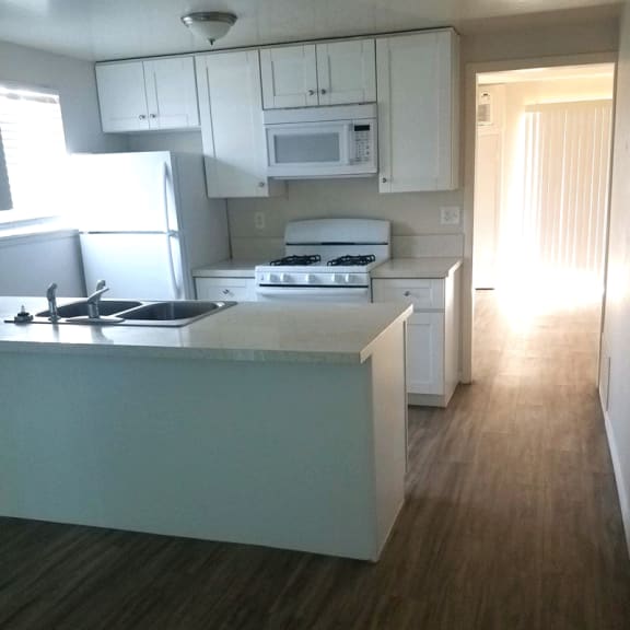 a kitchen with white cabinets and white appliances