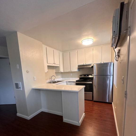 a kitchen with white cabinets and a stainless steel refrigerator
