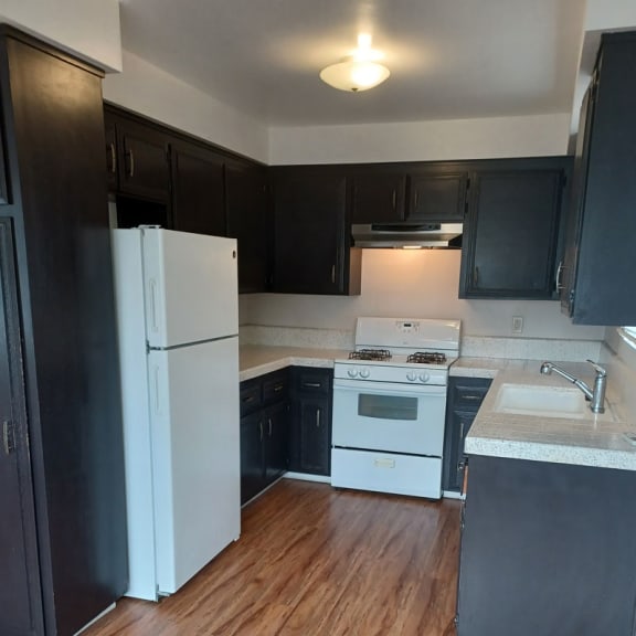 a kitchen with black cabinets and white appliances