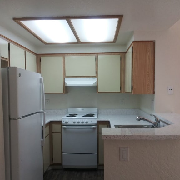 an empty kitchen with a refrigerator stove and sink