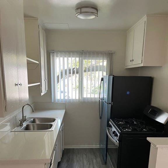 a small kitchen with a sink stove and refrigerator