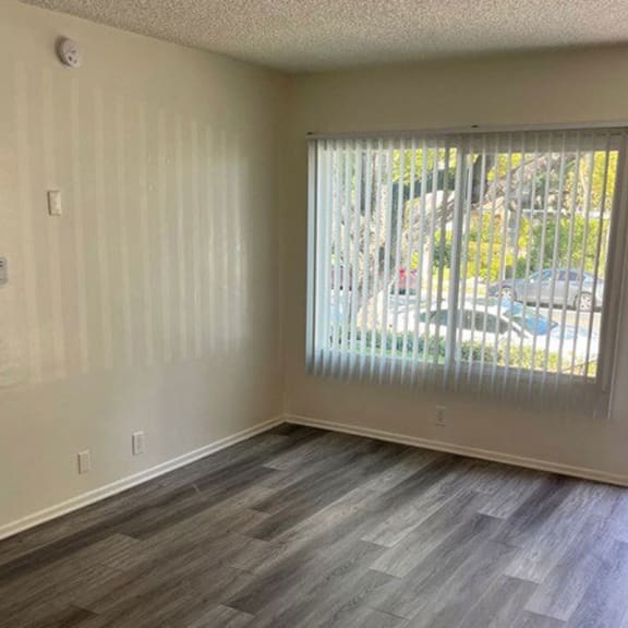 a bedroom with a large window and wooden floors