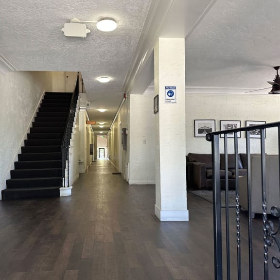 a hallway with a staircase in the background and a wooden floor in the foreground