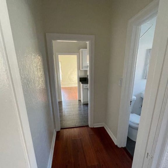a hallway with a toilet and a sink