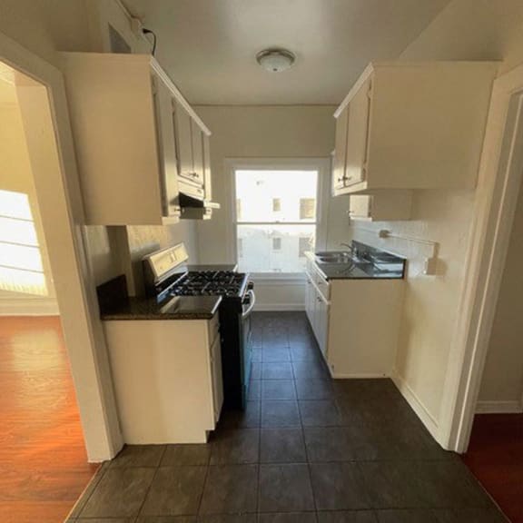 a kitchen with a stove top oven next to a window