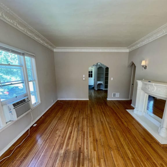 a living room with a fireplace and hardwood floors