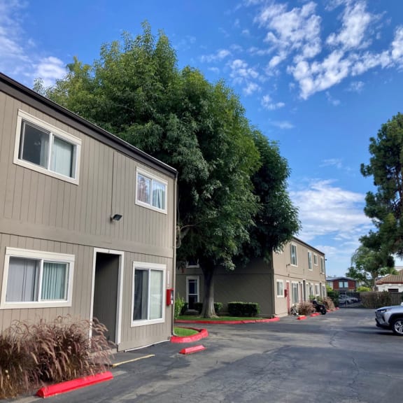 a row of apartment buildings in a parking lot with a blue sky in the background
