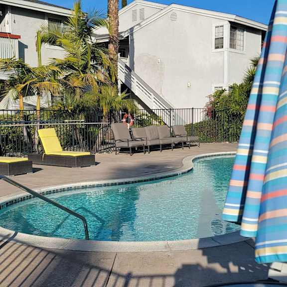 A pool with a metal railing and a yellow chair.