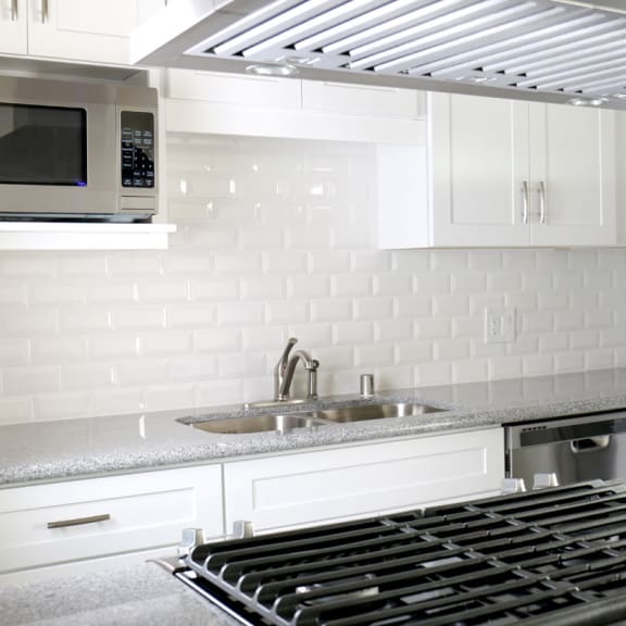 a kitchen with a stove top oven and a sink